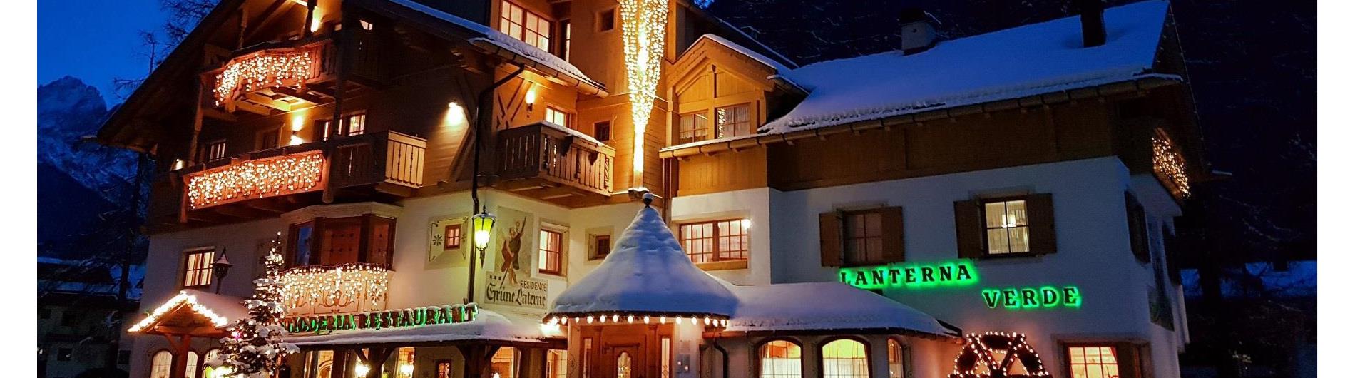 Vista esterna della Residence Lanterna Verde di notte in inverno con illuminazione natalizia