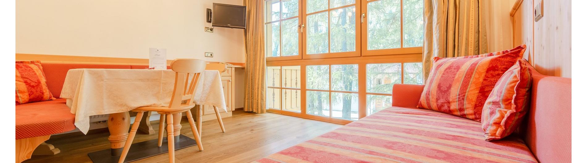 Zona pranzo inondata di luce con divano negli appartamenti