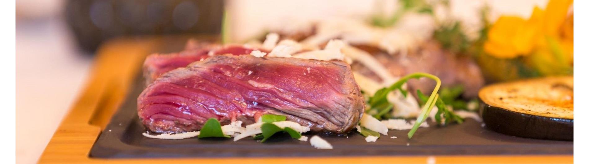 Sliced beef (tagliata) with arugula and Parmesan shavings