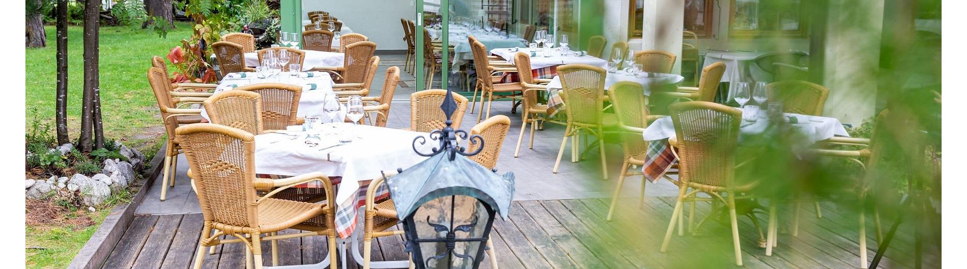 Ristorante con terrazza circondato da un bosco di larici