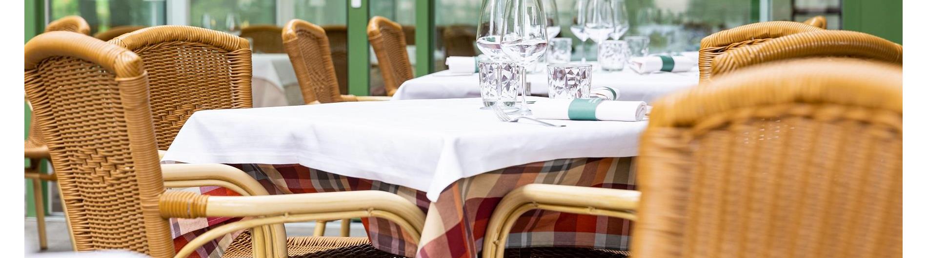 Außenbereich Restaurant mit hellen Terrassenmöbeln und Tischeindeckung