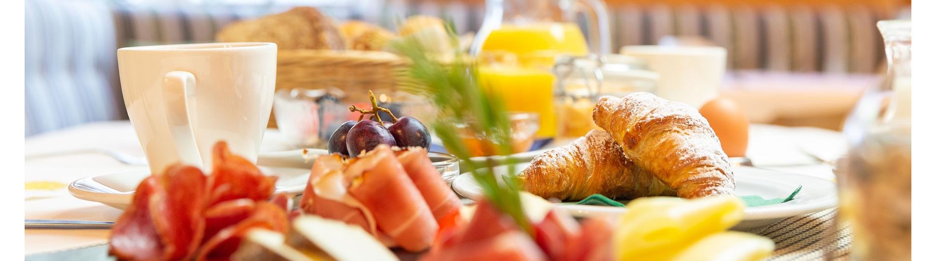 Frühstück: Speck, Käse, Croissants, Orangensaft