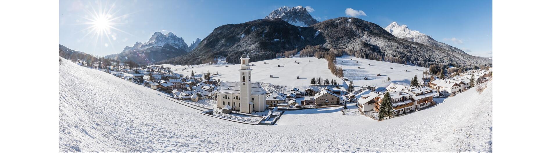 Winterbild über Sexten mit Blick von Oben. Gut zu erkennen die Kirche und der Schnee.