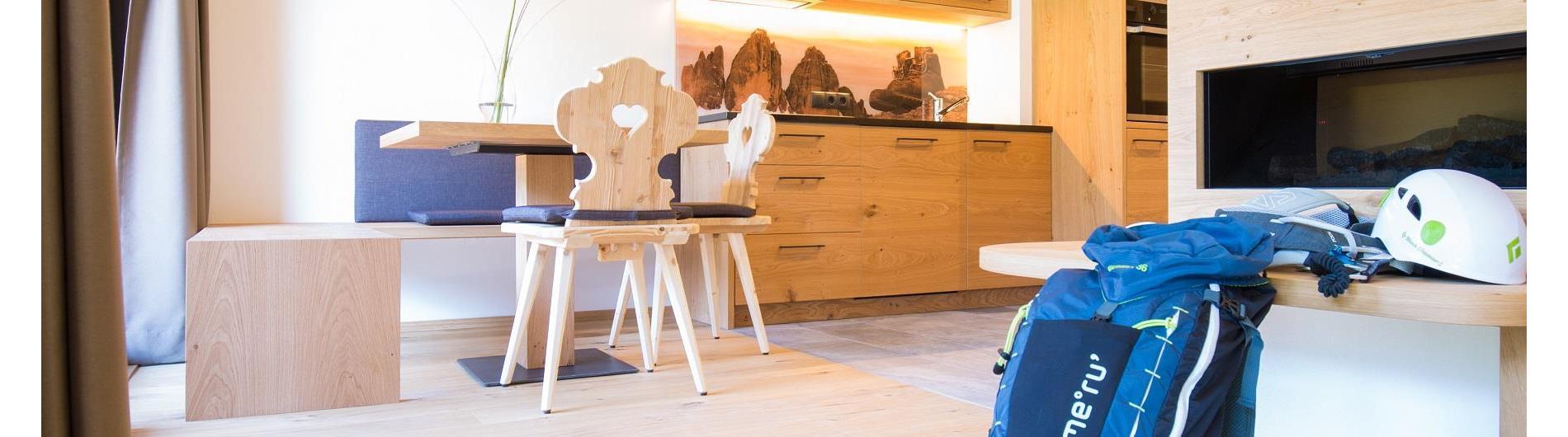 Vista verso la cucina e l’area pranzo nella villa. Zaino e casco già pronti per l’escursione alpina