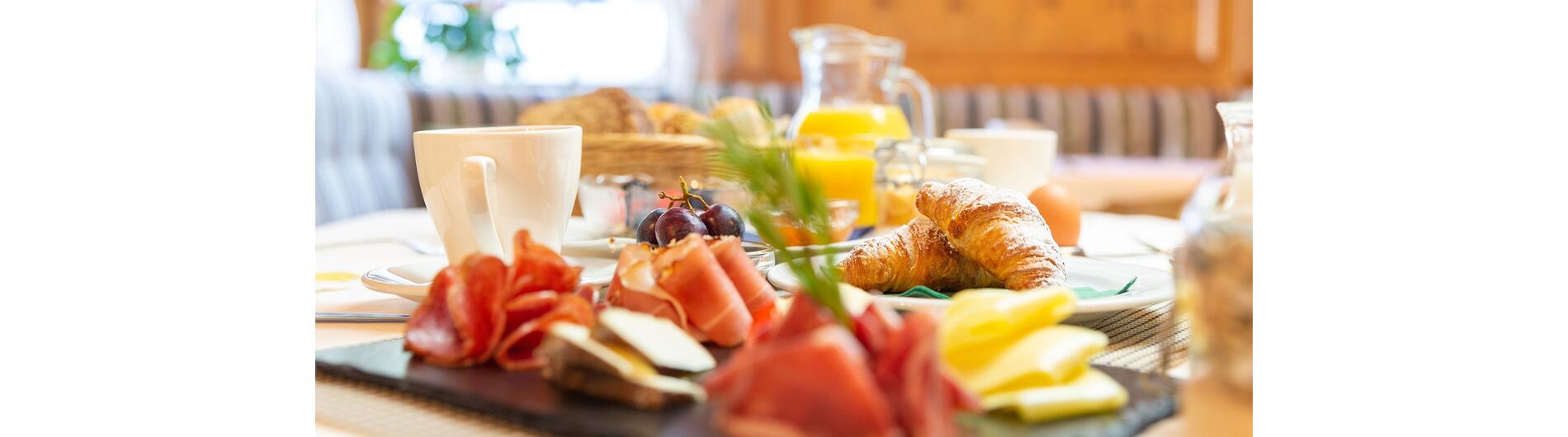 Breakfast: speck, cheese, croissants, orange juice