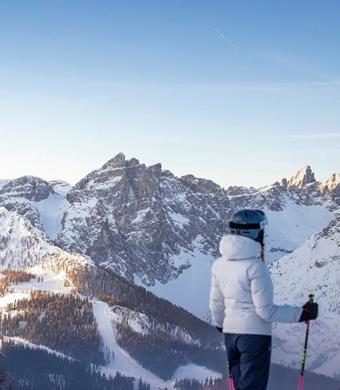 Zwei Skifahrer von hinten welche von der Piste aus die Zacken der 3 Zinnen beobachten