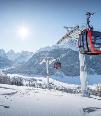 Die Kabinenbahn Helmjet im winterlichen Betrieb mit schöner Aussicht auf die Sextner Sonnenuhr