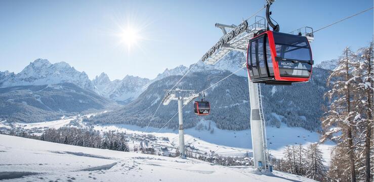 Die Kabinenbahn Helmjet im winterlichen Betrieb mit schöner Aussicht auf die Sextner Sonnenuhr